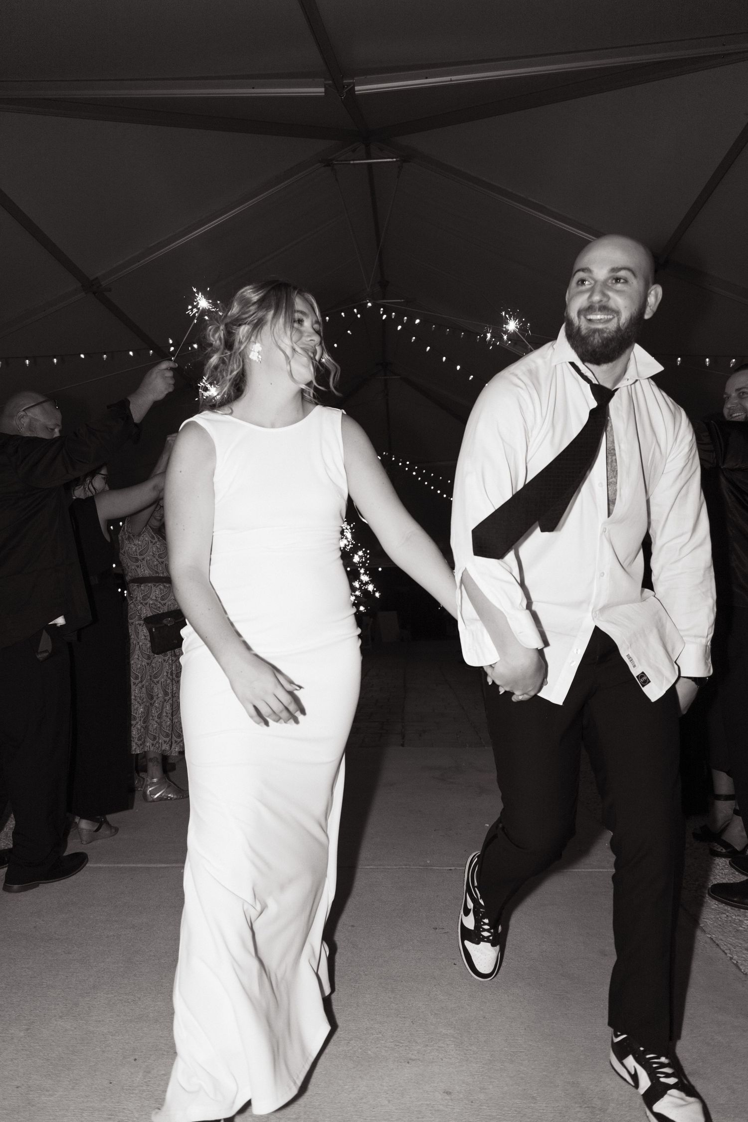 Black and white photo sequence showing dancers in white and black outfits performing energetic dance moves on a dance floor.