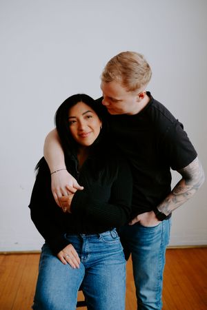 Couple in matching outfits share candid moments during indoor photo session.