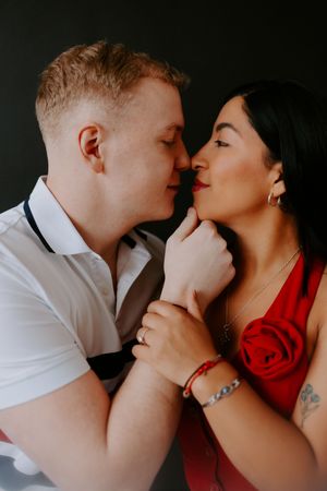 Romantic couple portrait with dramatic lighting showing tender embrace.