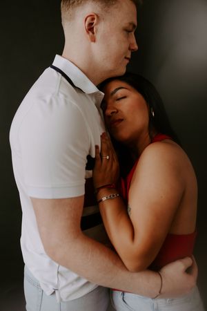 Intimate couple photography with moody lighting showing gentle embrace.