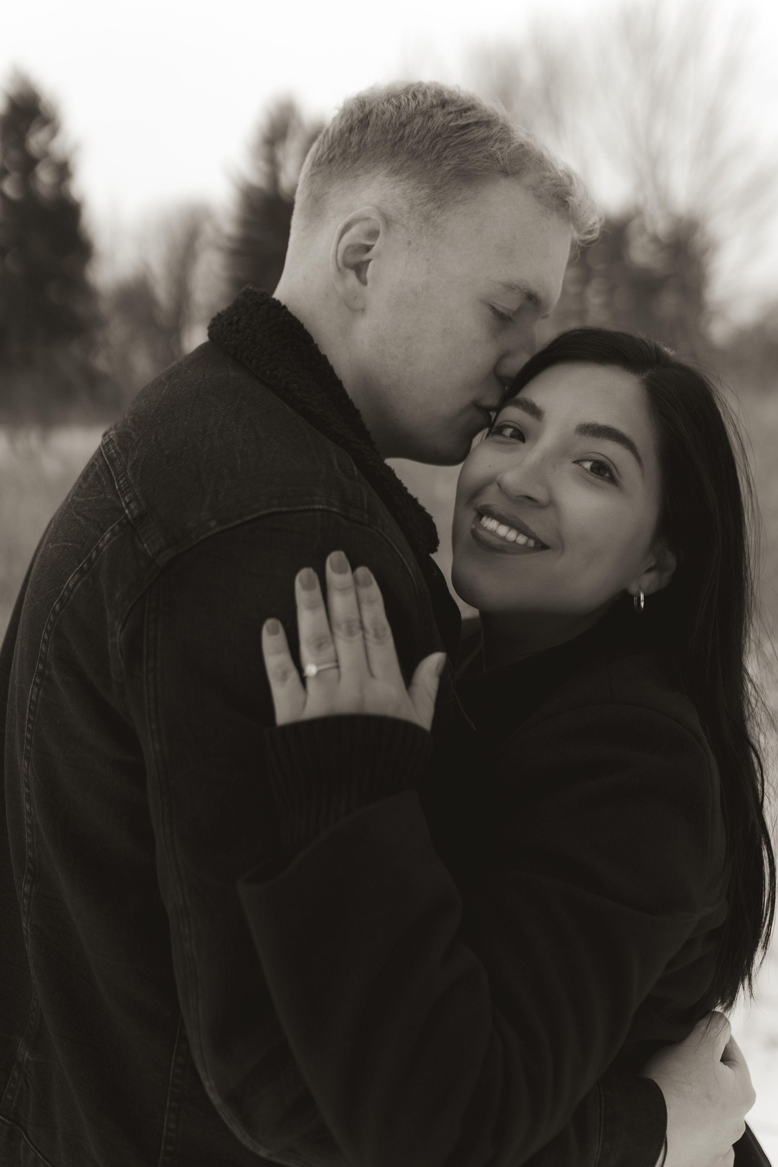 A black and white intimate portrait of a couple sharing a romantic moment together.