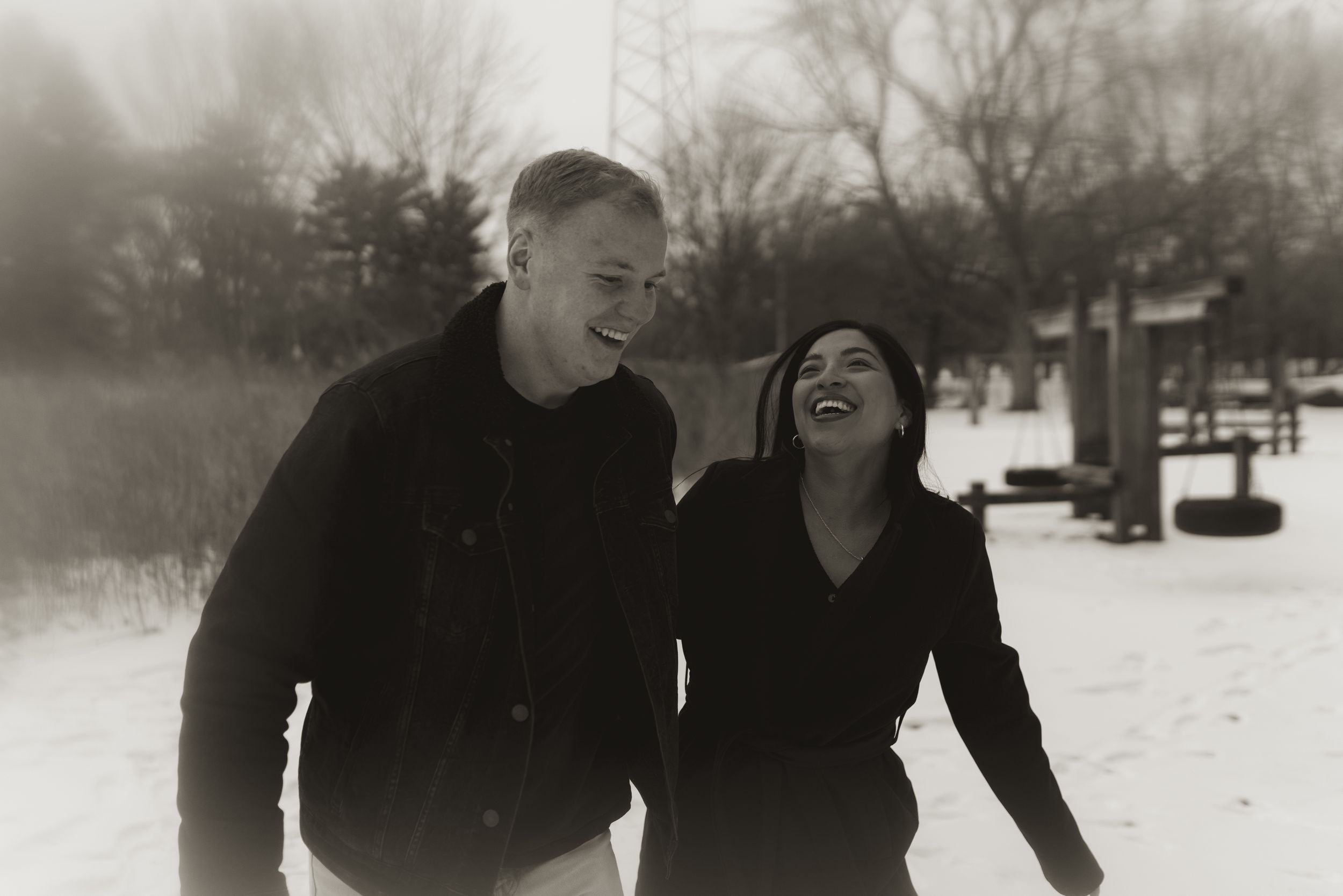 Winter engagement photography session showing joyful moments between a couple in the snow.