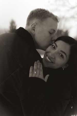 An intimate black and white photo of a couple embracing in winter.