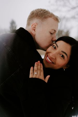 A romantic close-up portrait of a couple sharing an intimate moment outdoors.