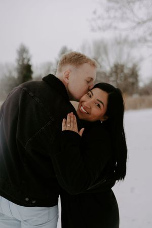 An intimate winter photoshoot showing a couple's tender embrace.