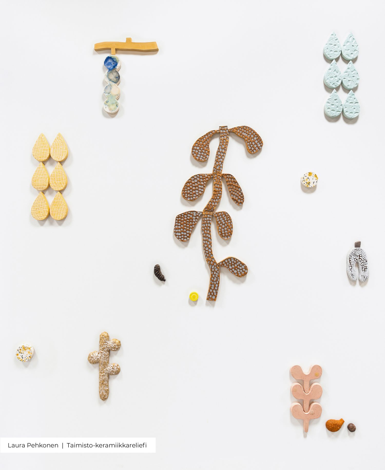 Ceramic wall art pieces by Laura Pehkonen featuring organic shapes, leaves, and textured forms in pastel colors on white background.