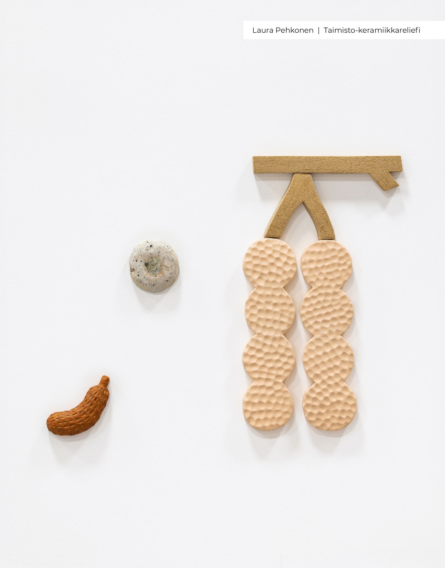 Ceramic wall art by Laura Pehkonen featuring handmade crackers on a rack, a stone, and a small banana sculpture.