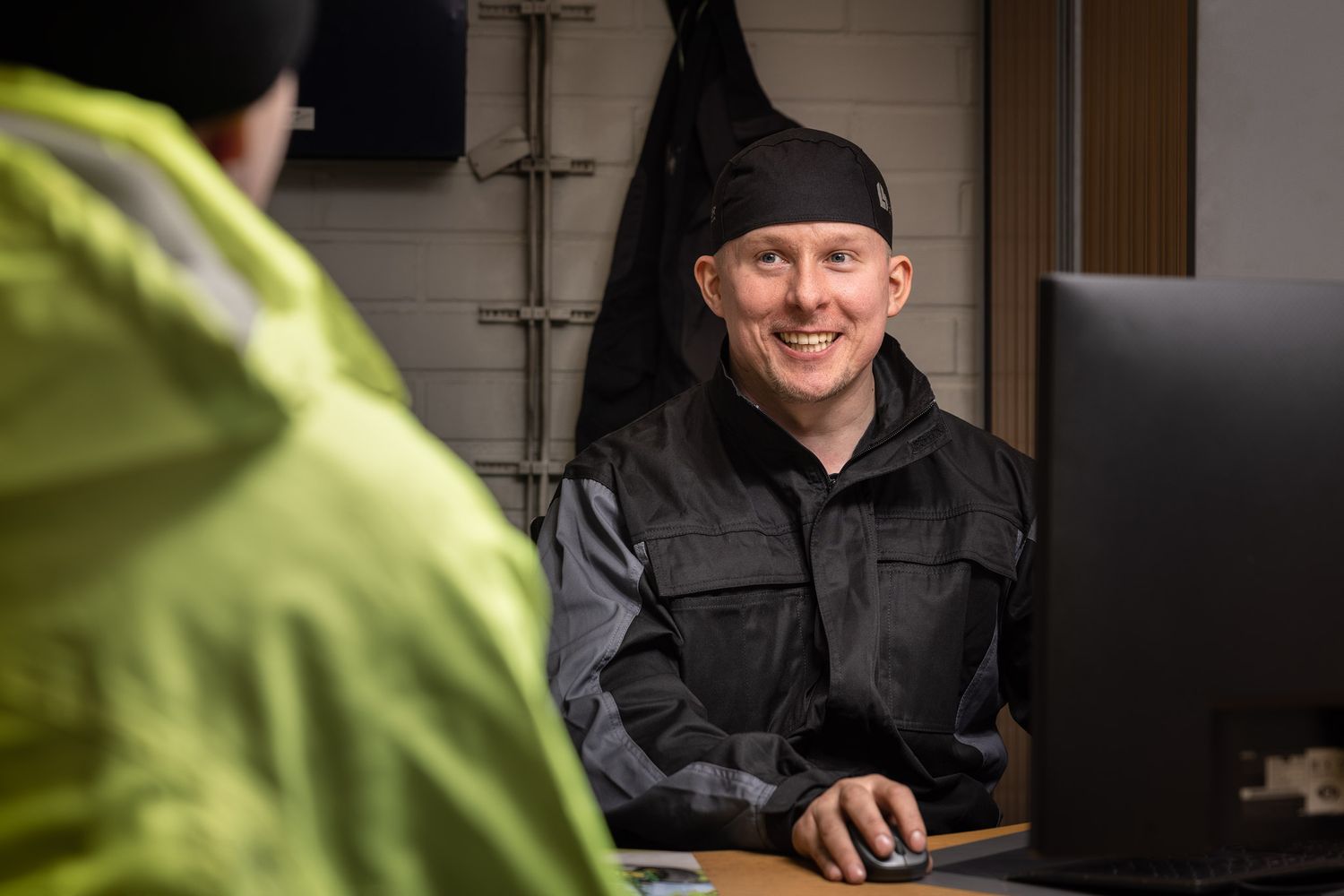 Työmies istuu työpöydän ääressä.