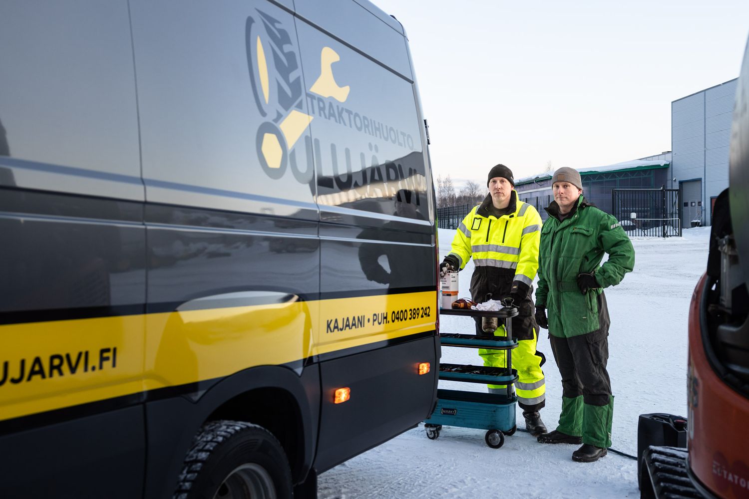 Työhaalareihin pukeutuneita työmiehiä pakettiauton perässä.