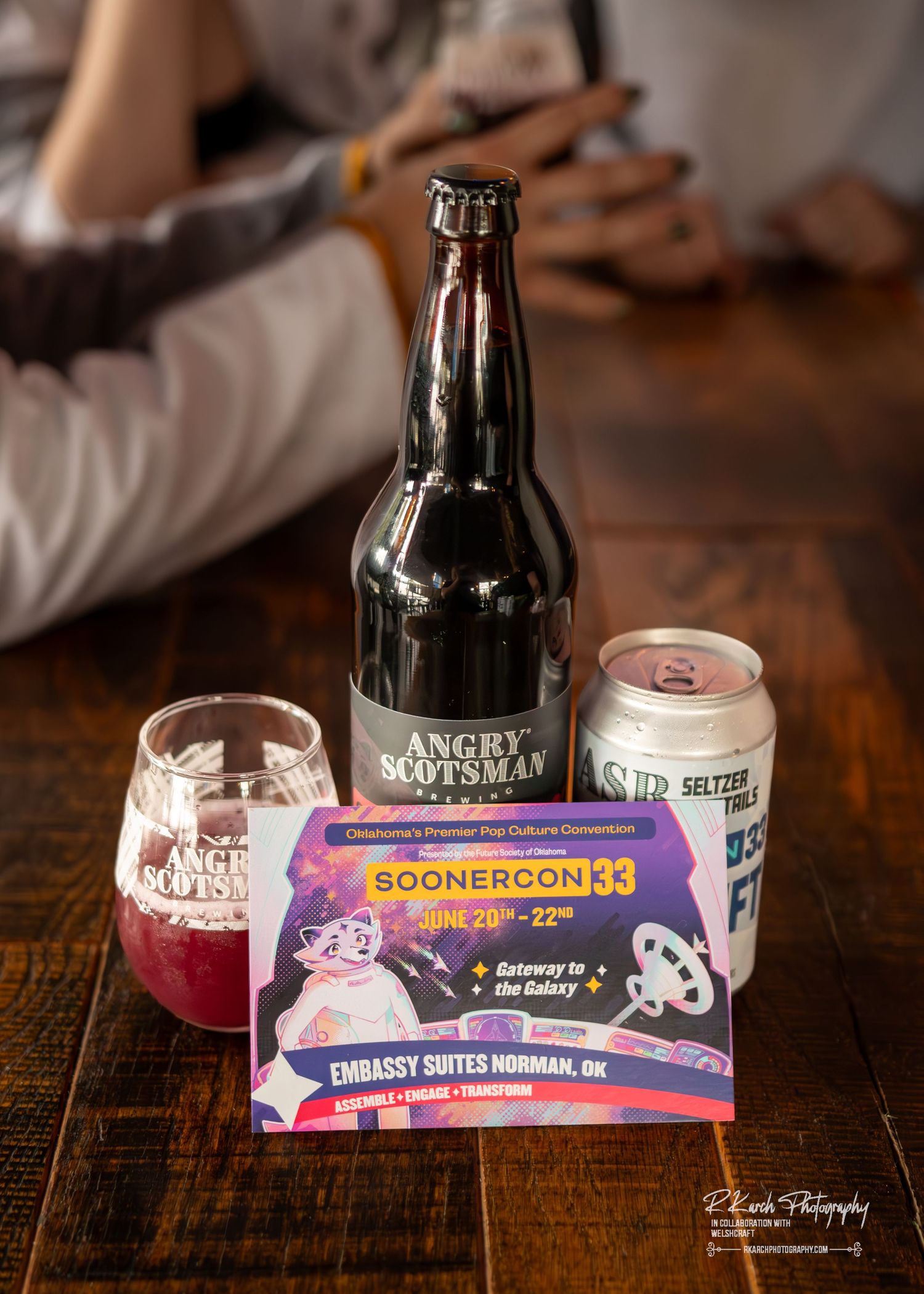 Several artisanal craft beers and ice cream pints arranged on a rustic wooden table showing a SoonerCorn ice cream brand package.