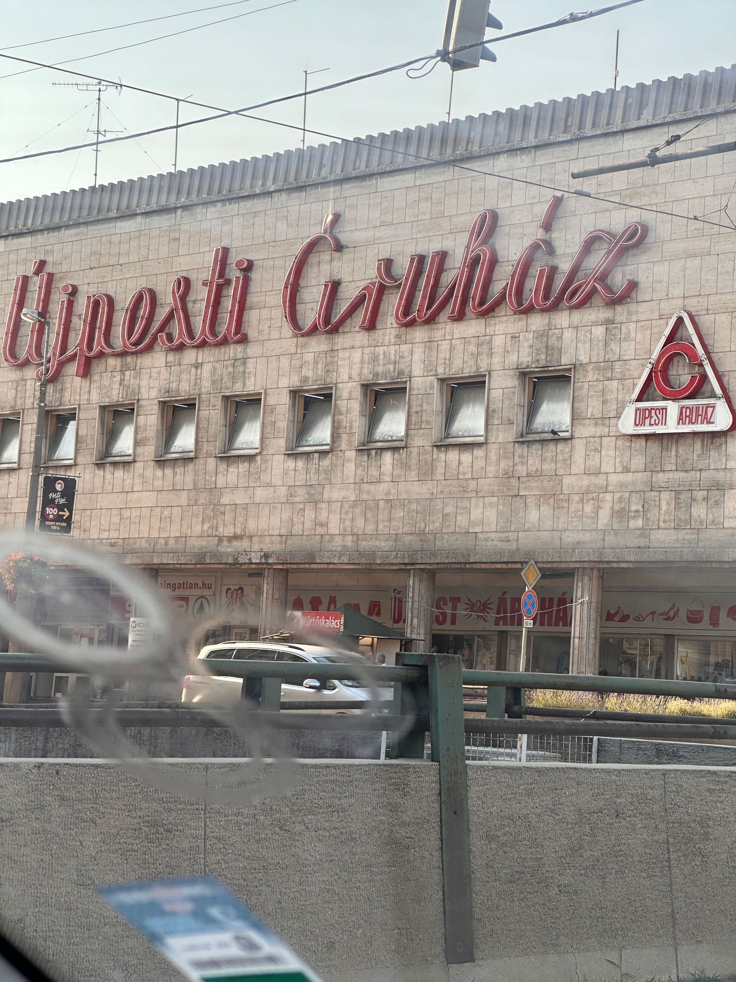 Exterior view of a vintage Dynast Gruhaz building with retro signage and a triangular logo on a stone facade.