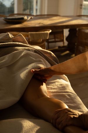 Professional massage therapy session showing hands applying treatment in warm lighting.