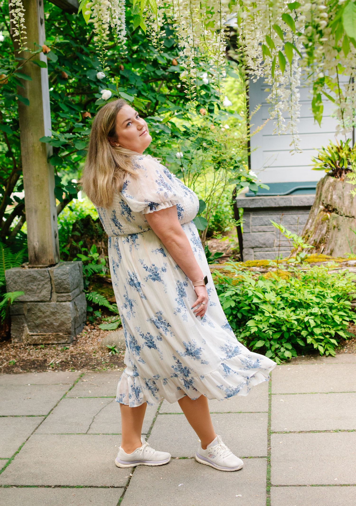 Confident twirl among wisteria vines at Washington Park Arboretum – spring portrait session.