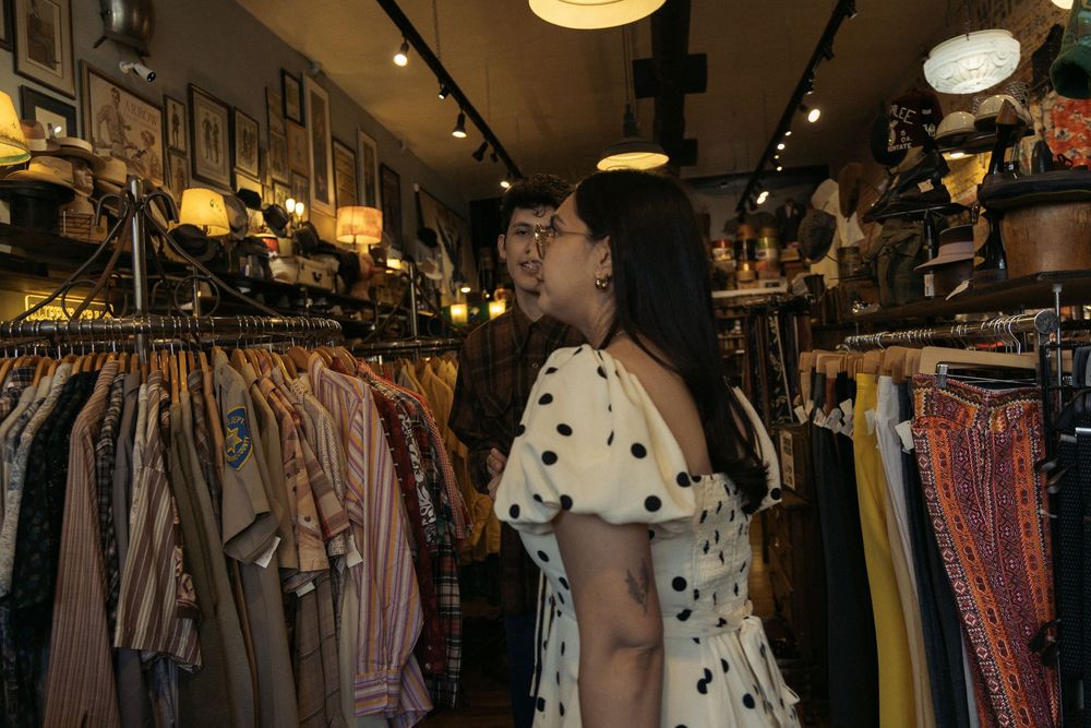 A vintage clothing store interior features racks of colorful garments and retro decor.