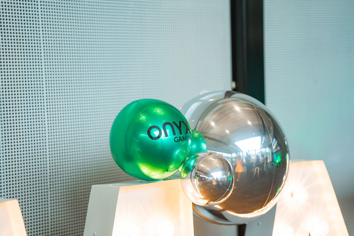 Green and clear glass orb decorations sit on white surfaces against a light-colored wall.