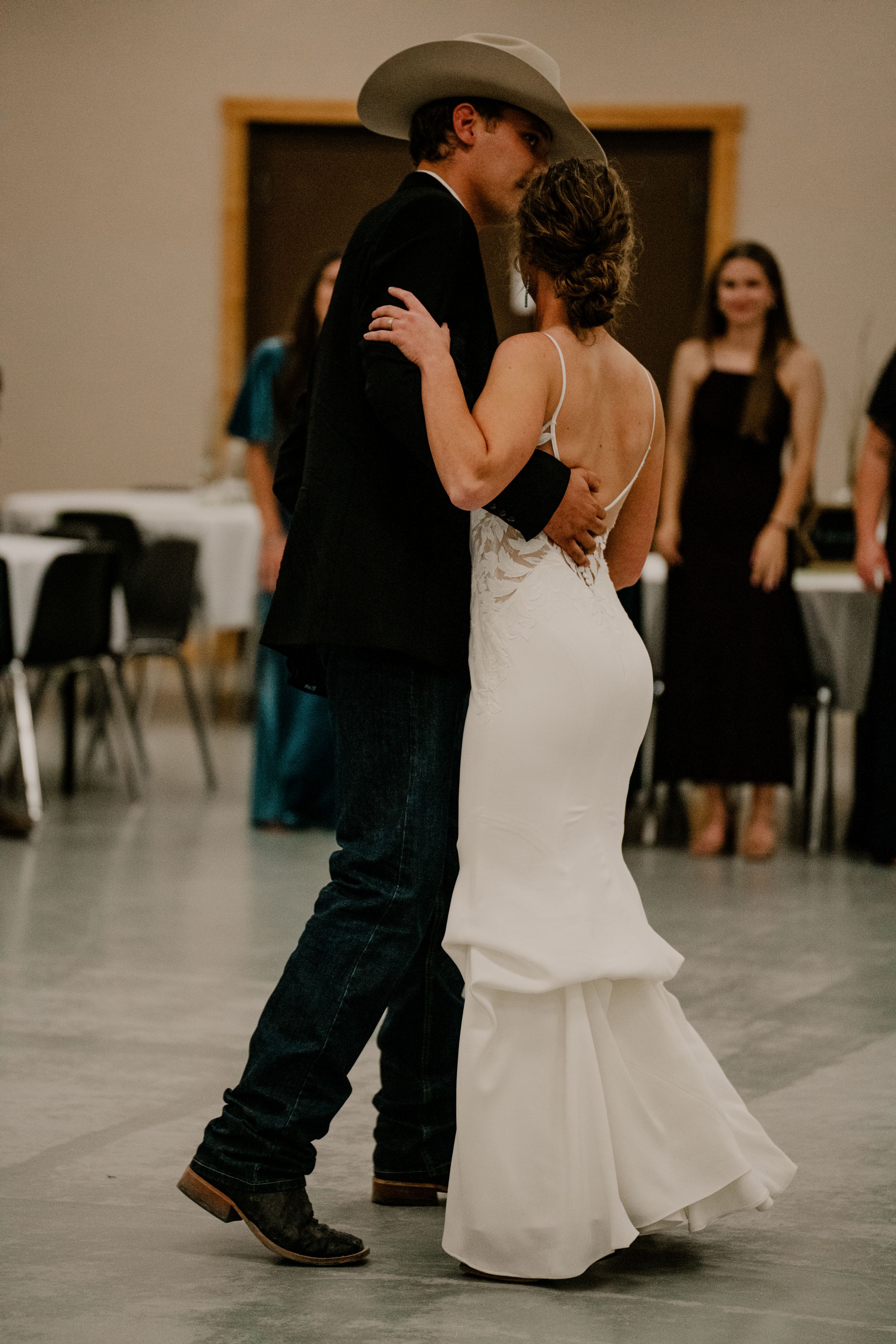 A newly married couple experiencing their first dance in front of friends