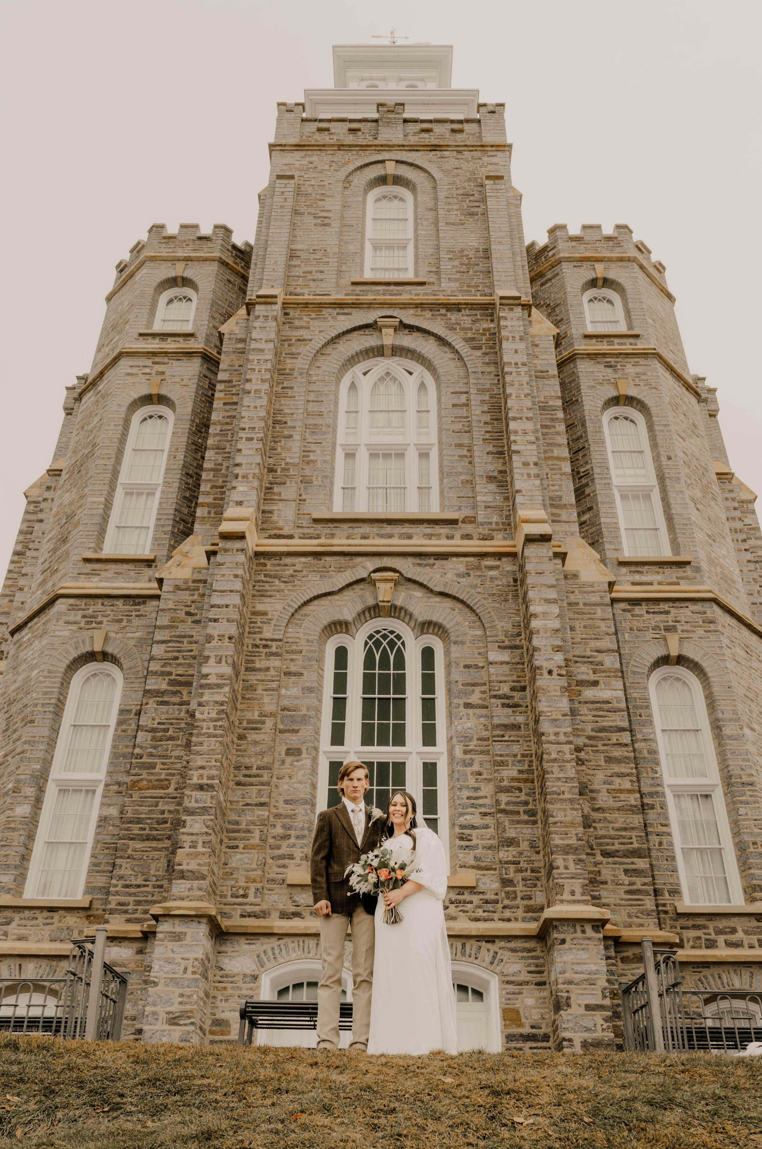 A newly married couple standing in front of the Logan LDS Temple