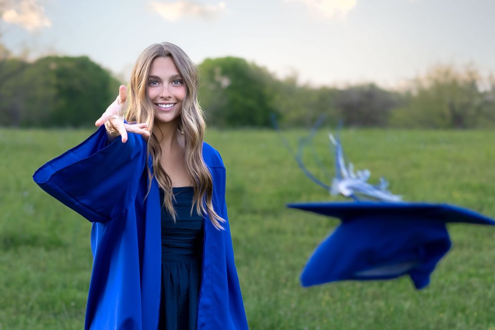 Senior girl in her graduation gown throwing her cap at sunset – Athens GA senior photographer