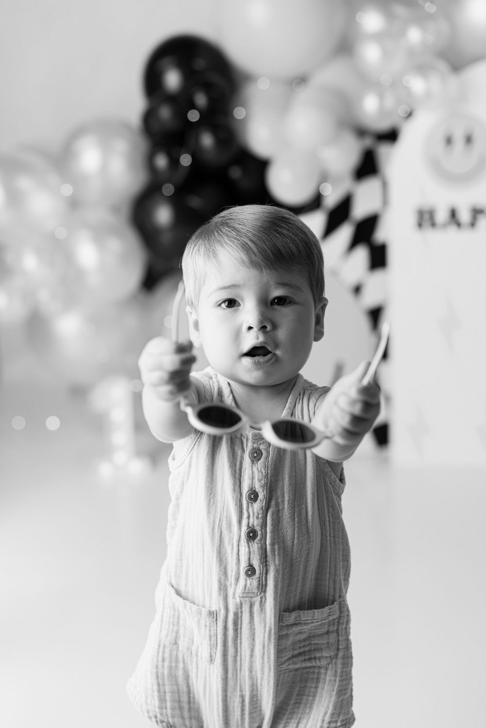 Black and white portrait against balloon backdrop.