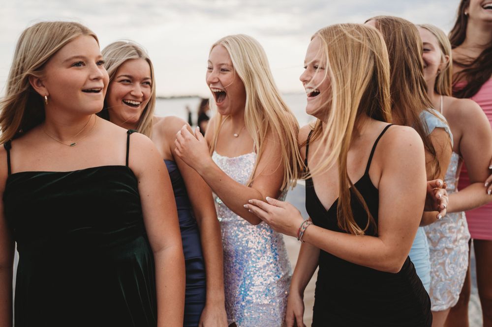 Candid shot of friends sharing genuine laughter during an outdoor photoshoot.