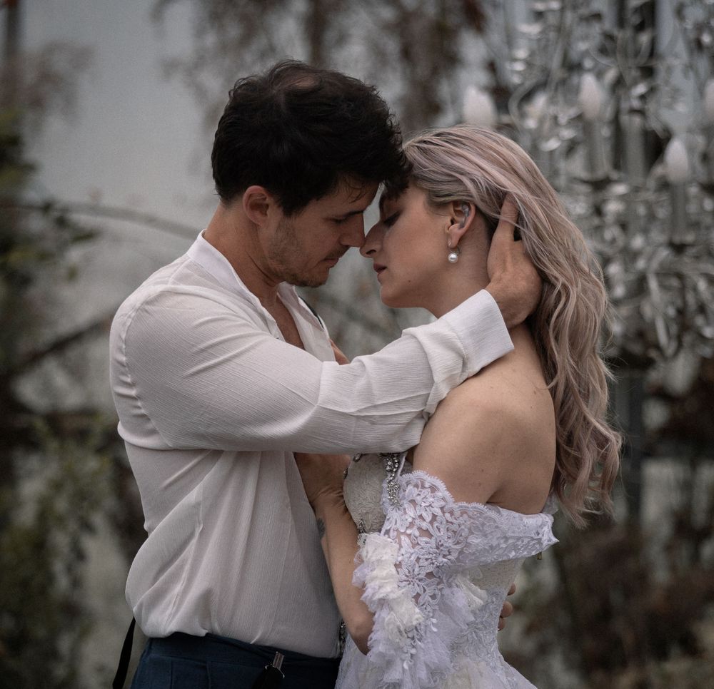 A romantic couple embraces in an intimate moment in a greenhouse .