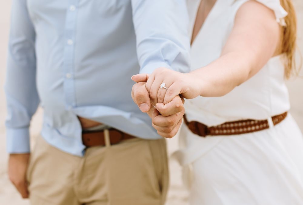 Close up photo of engagement ring of couple clasping hands together for engagement photos. Bedford Amherst engagement photographer