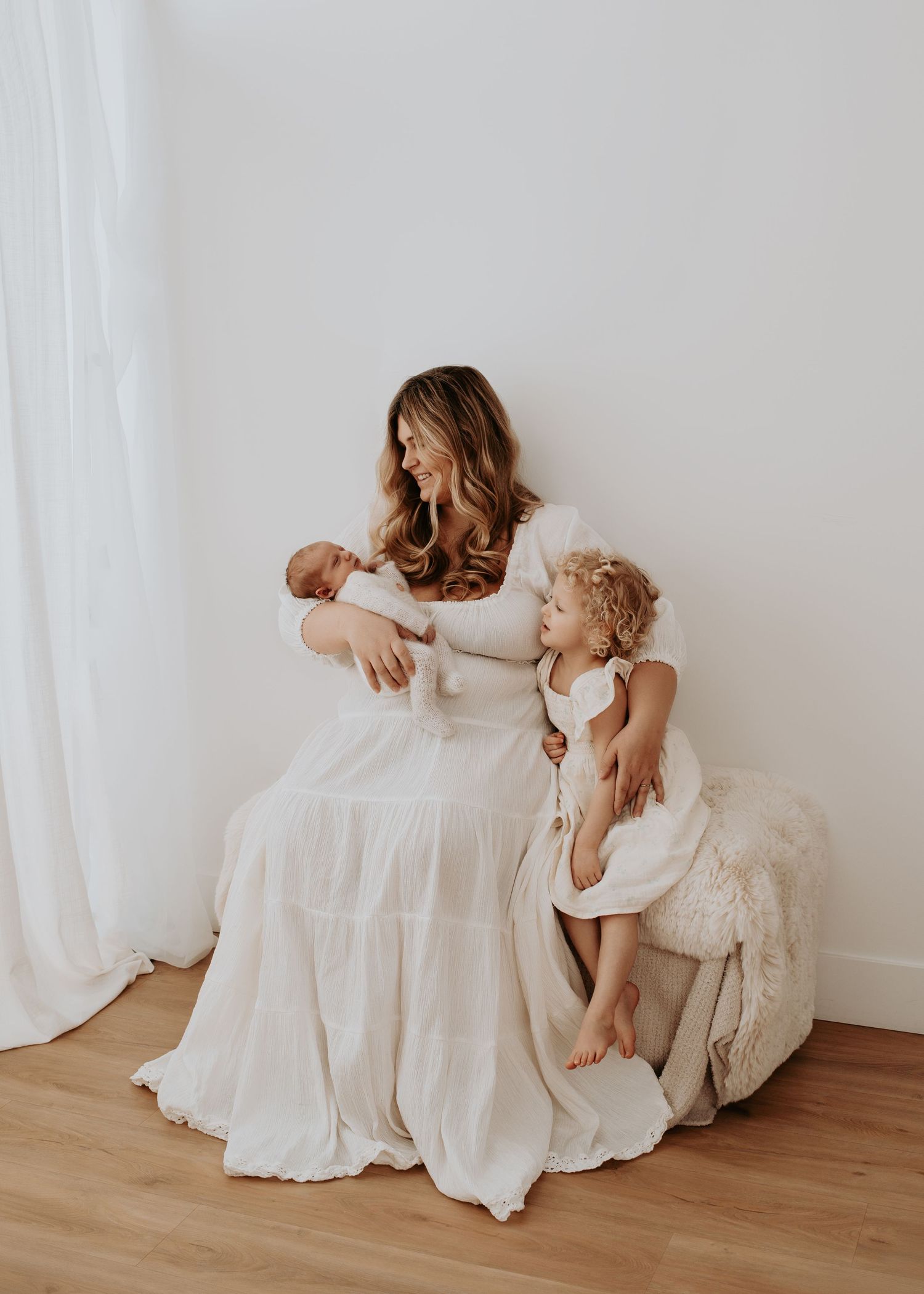 Family gathered around their newborn baby during a lifestyle newborn photography session in Osoyoos, BC.