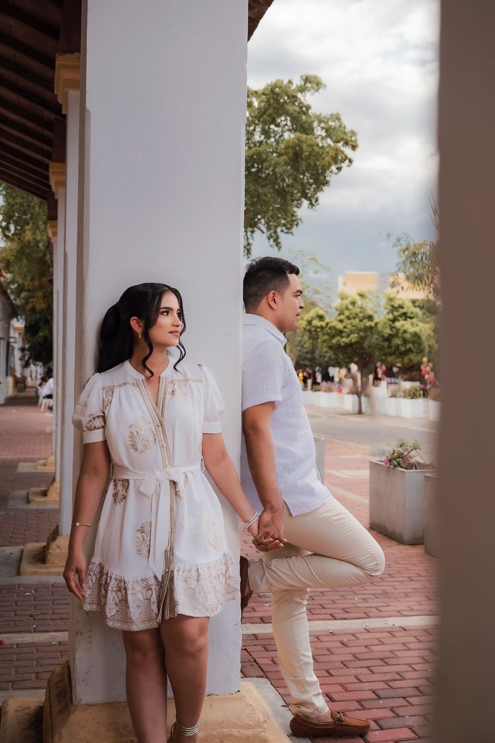 Novios posando contra la arquitectura colonial del Valledupar tradicional, capturados con rigor cinematográfico.