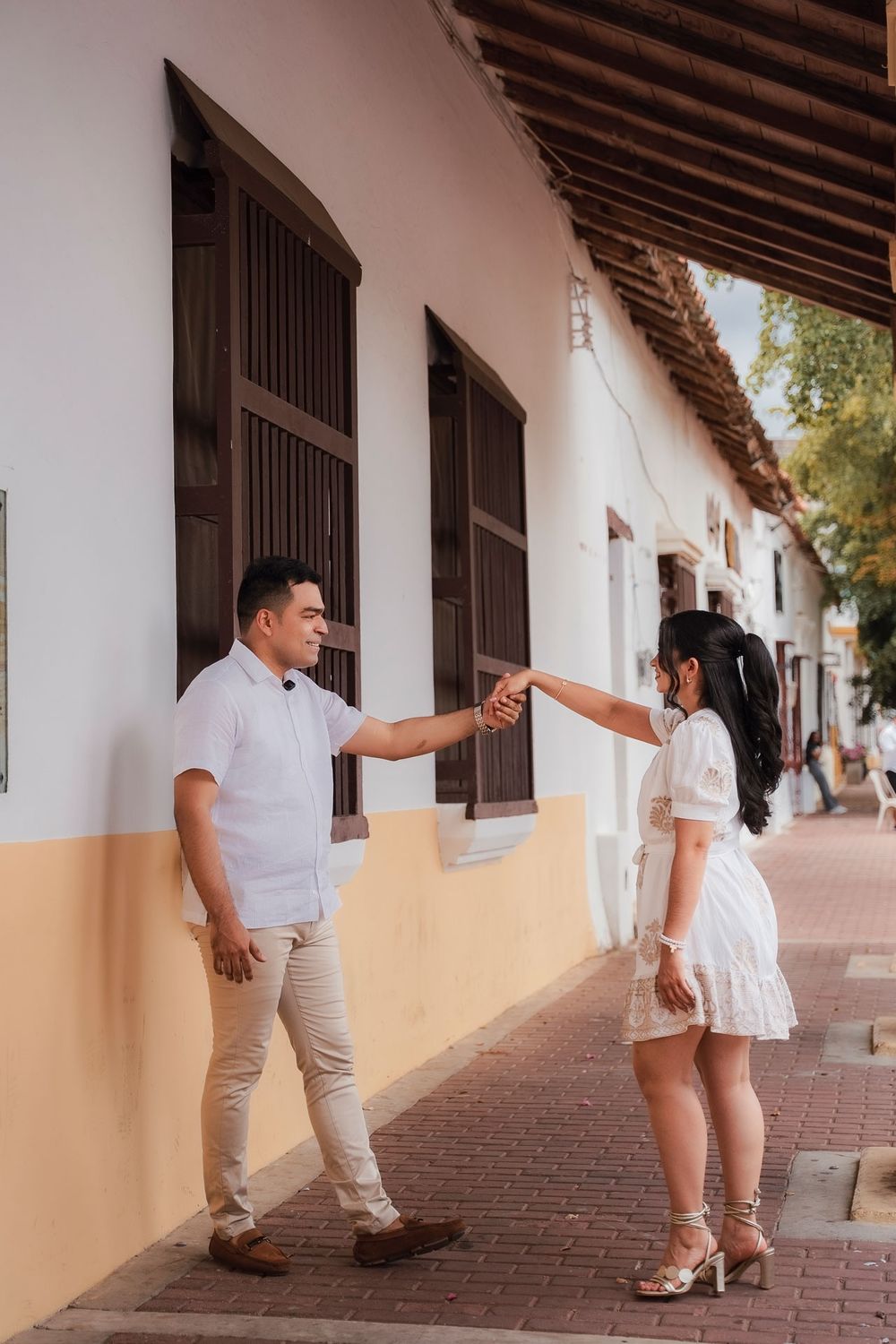 Novios posando contra la arquitectura colonial del Valledupar tradicional, capturados con rigor cinematográfico.