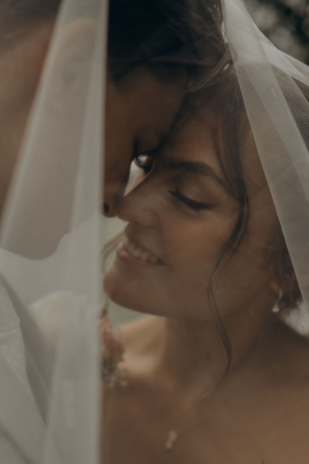 bride and groom touching with their foreheads under bride's veil while being captured by wedding photographer in Sweden