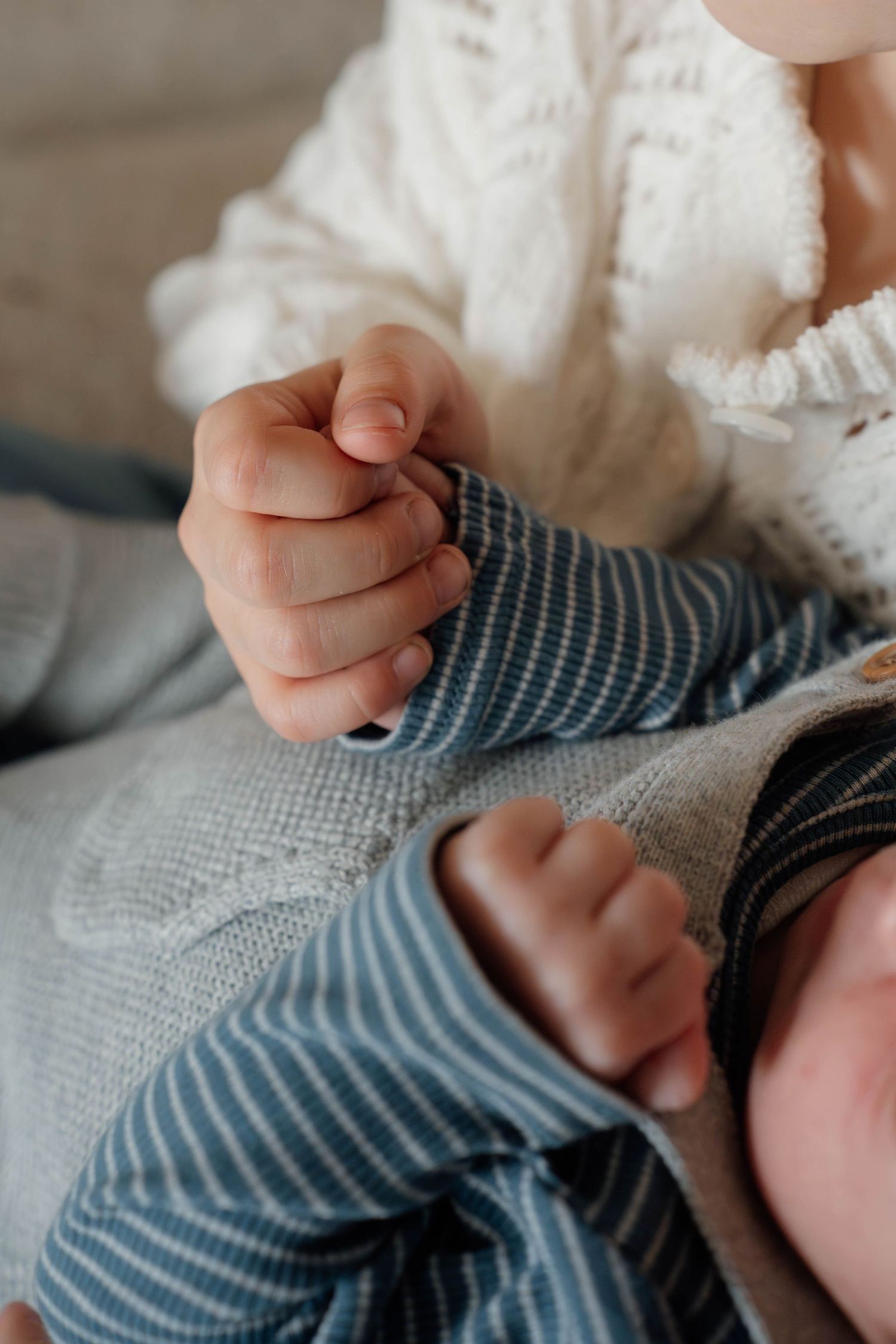 Close-up detail photo of newborn baby hands during cozy in-home newborn and family photography session in Spokane.