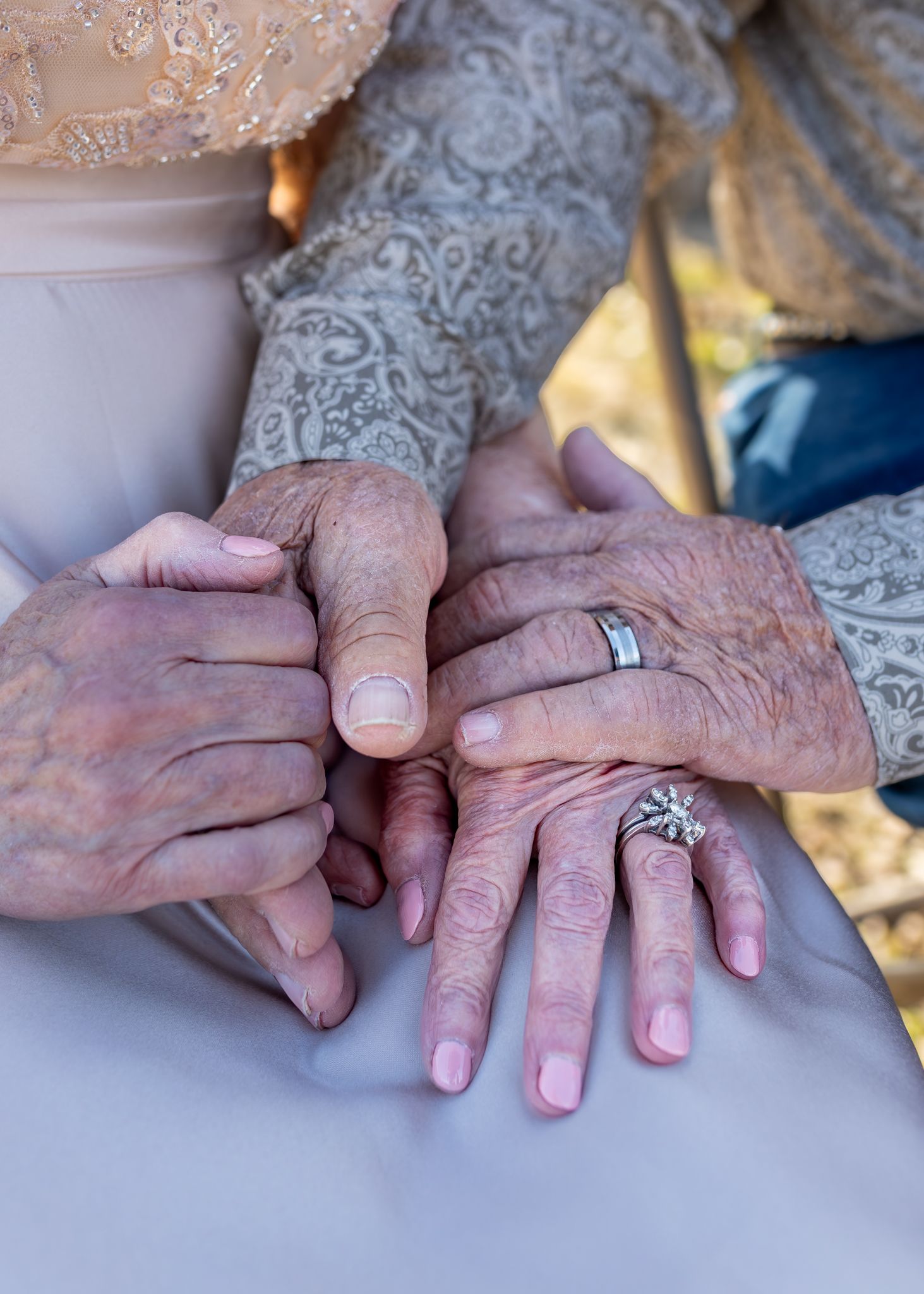 Elderly couple holding hands showing wedding rings, symbolizing lasting love and marriage commitment.