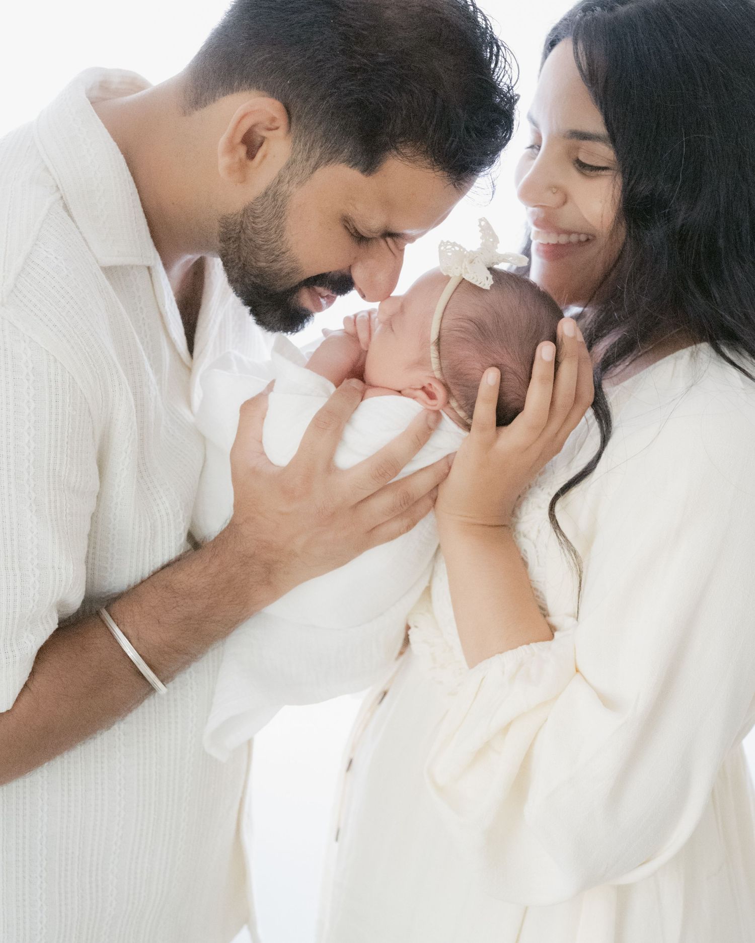 Parents snuggle their baby together