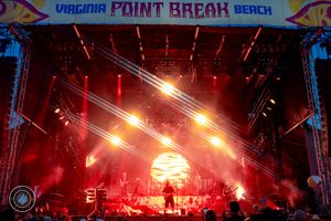 Virginia Point Break Beach festival stage illuminated with dramatic red and yellow lighting at night.