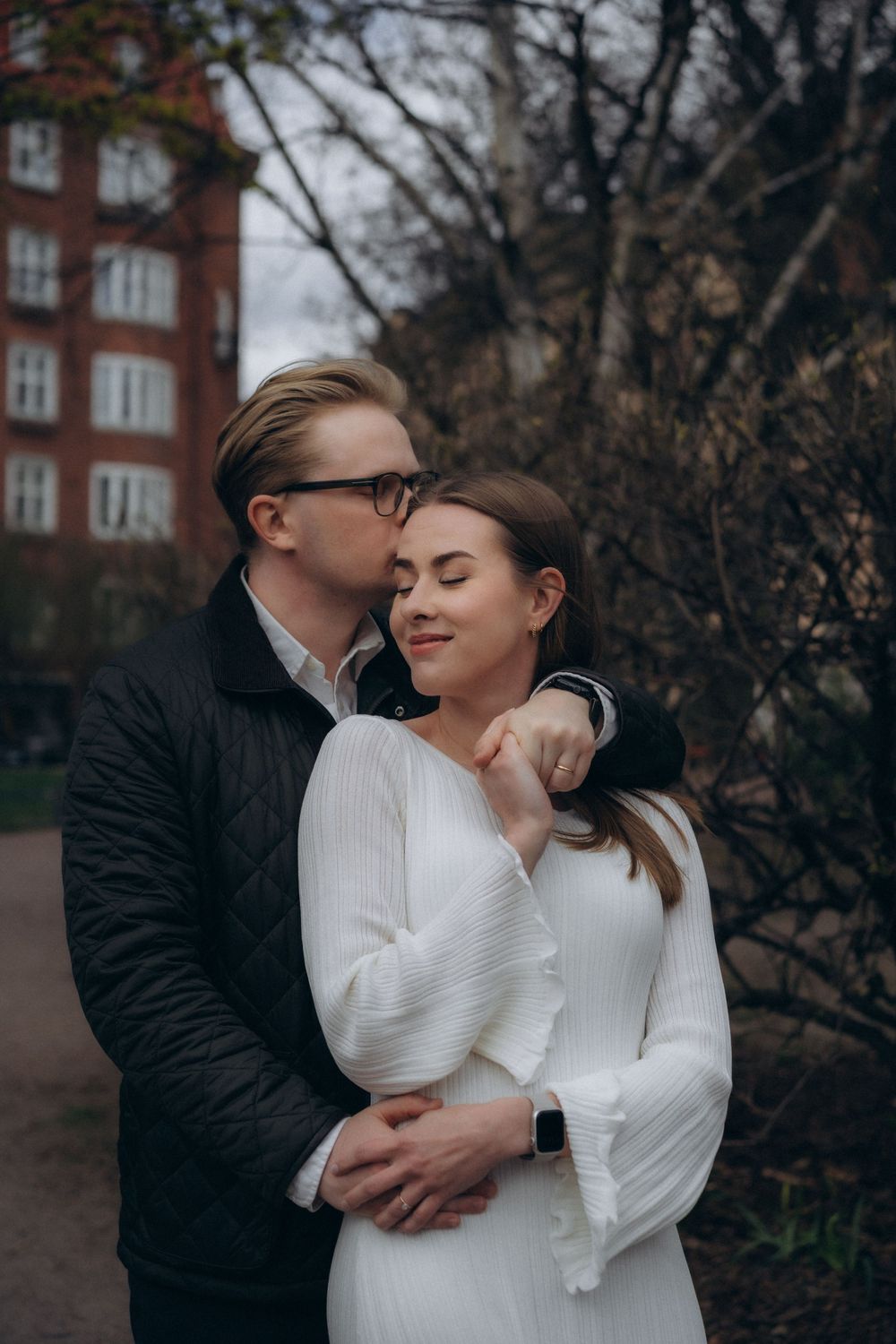Engaged couple embracing in Helsinki city centre during a relaxed urban couple photoshoot