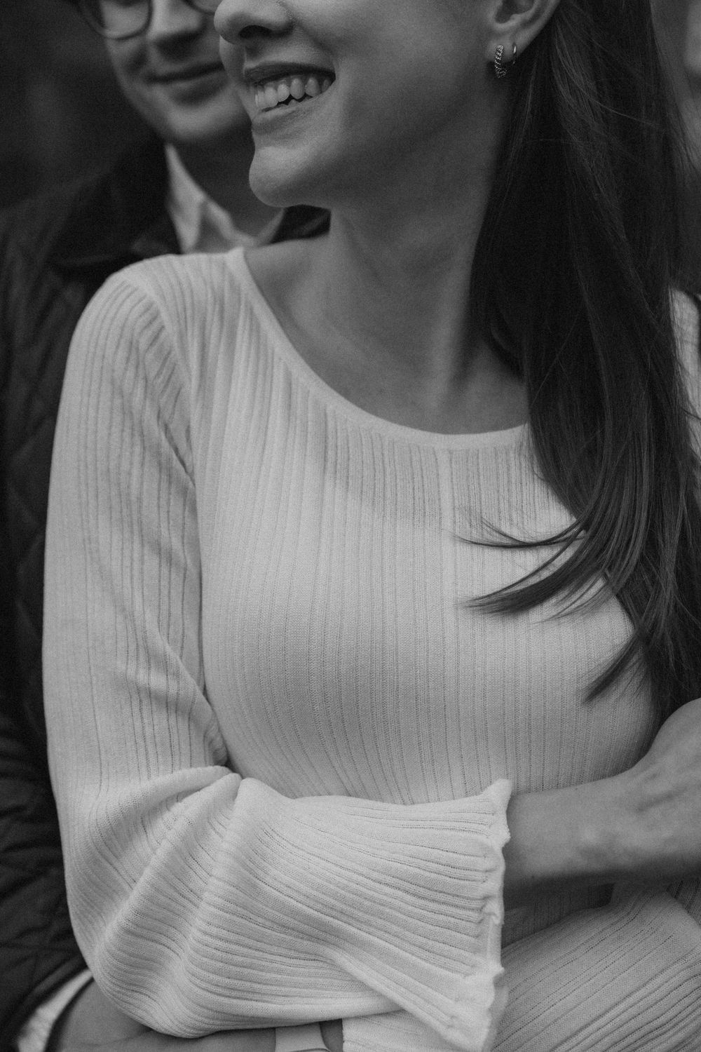 Black and white engagement photo of a woman laughing naturally during a couple session in Helsinki
