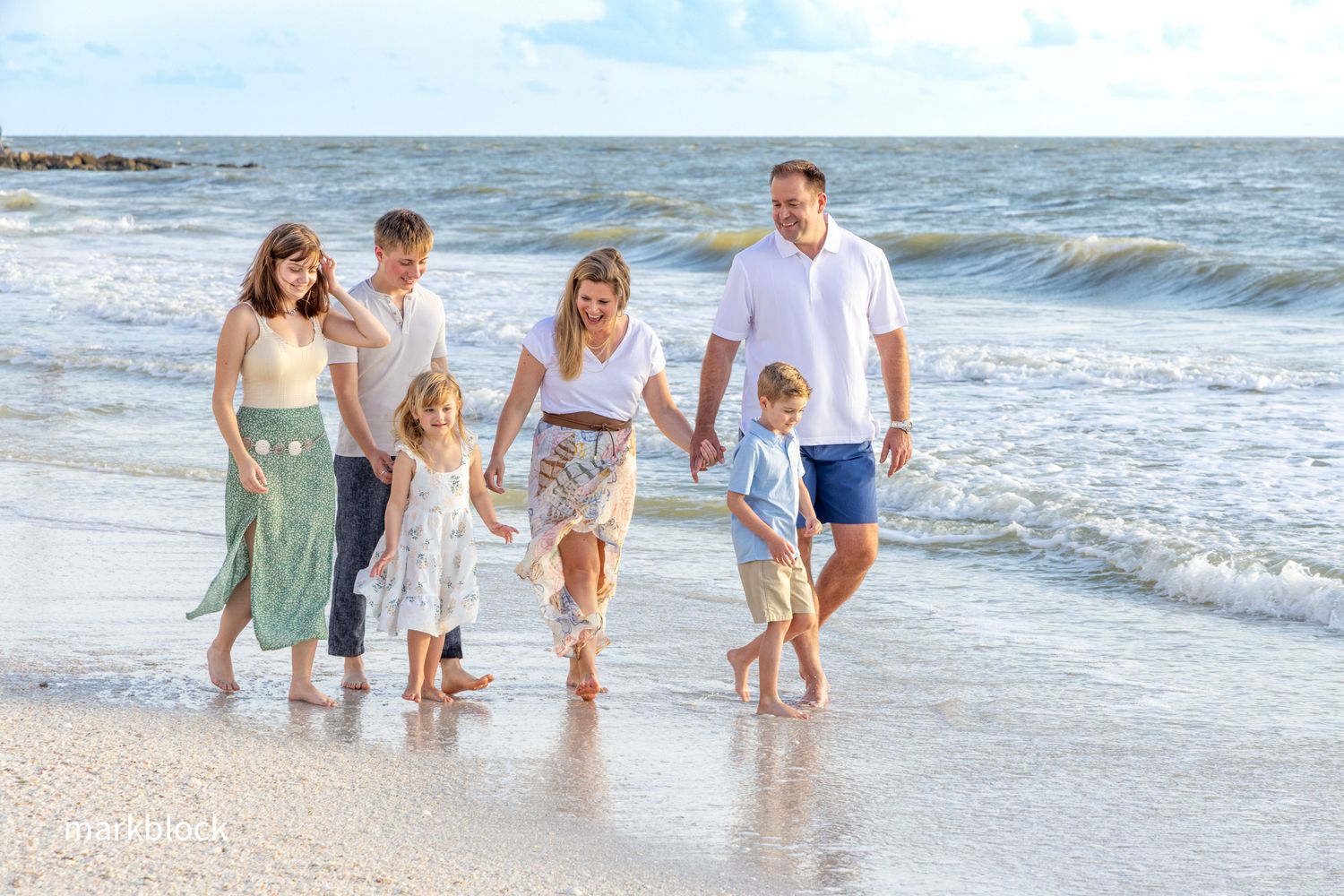 A photo by Mark Block, Naples photographer, of family strolling along the Naples, FL shoreline at sunset.