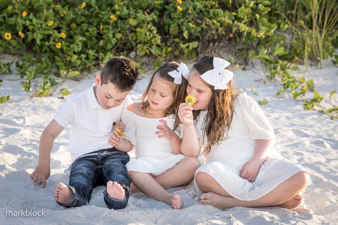 Marco Island Family photography of children lounging together on pristine beach at JW Marriott during sunset photo session.