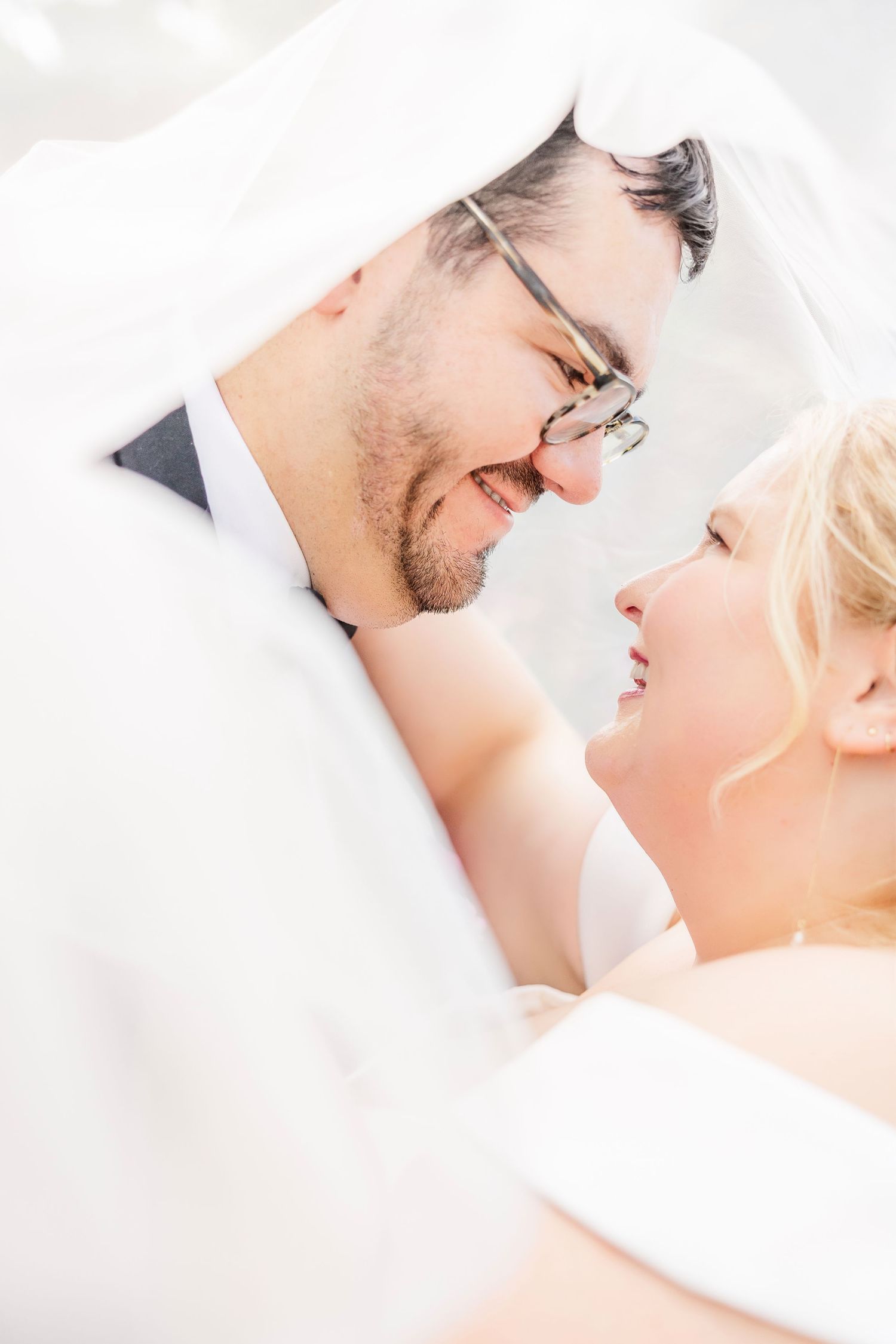 A romantic wedding couple shares a playful dance moment in a lush garden setting surrounded by spring blossoms.