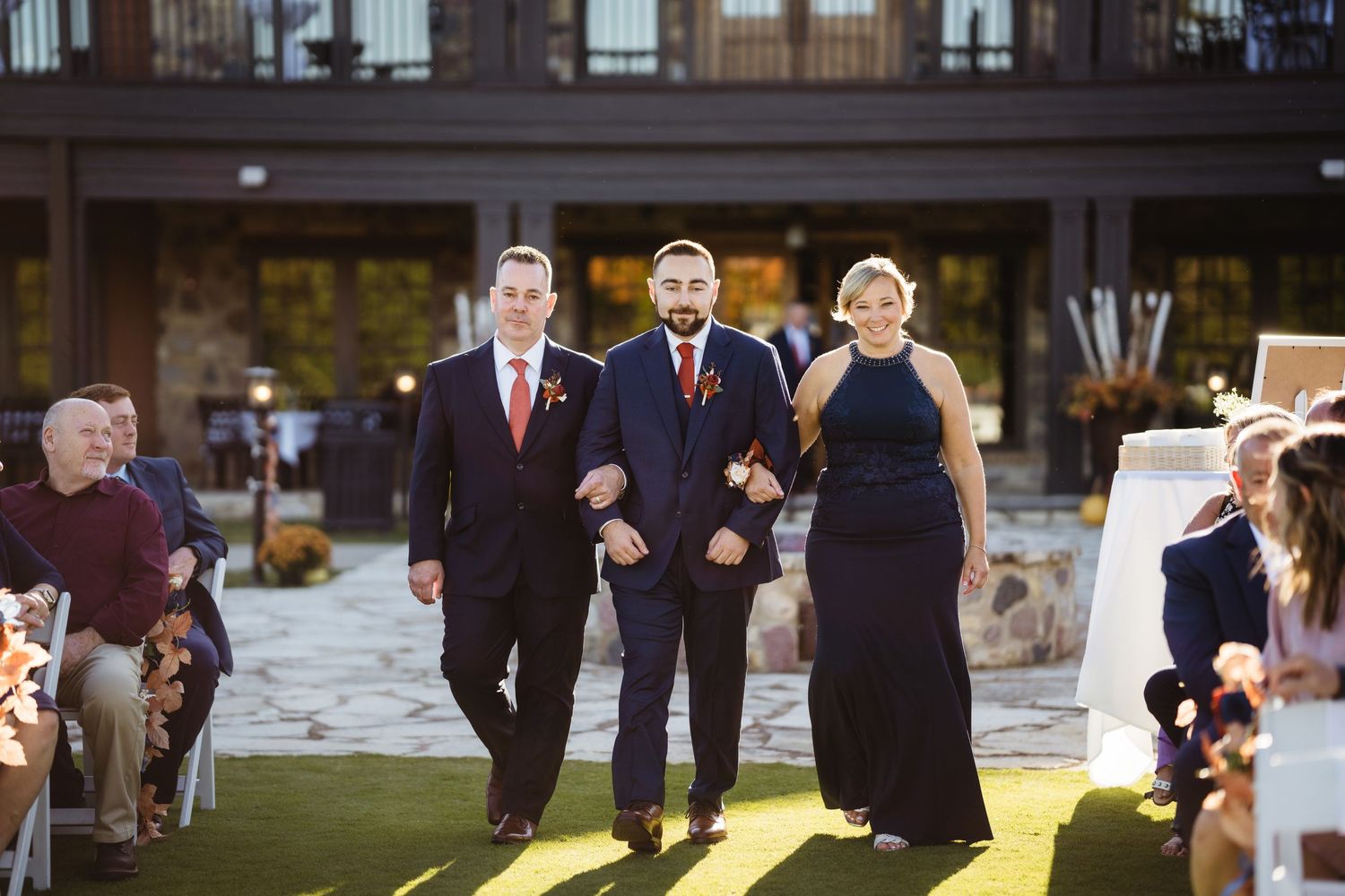 Wedding ceremony guests gather outdoors in formal attire during an elegant celebration.