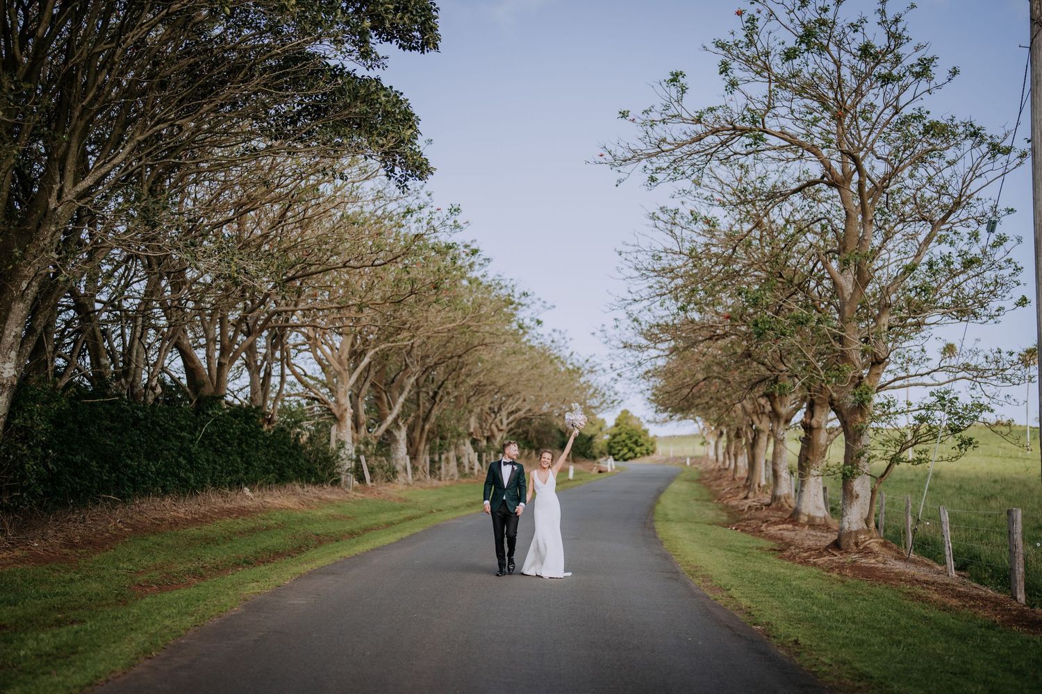 Tree-lined pathway at a scenic outdoor wedding venue during golden hour.
