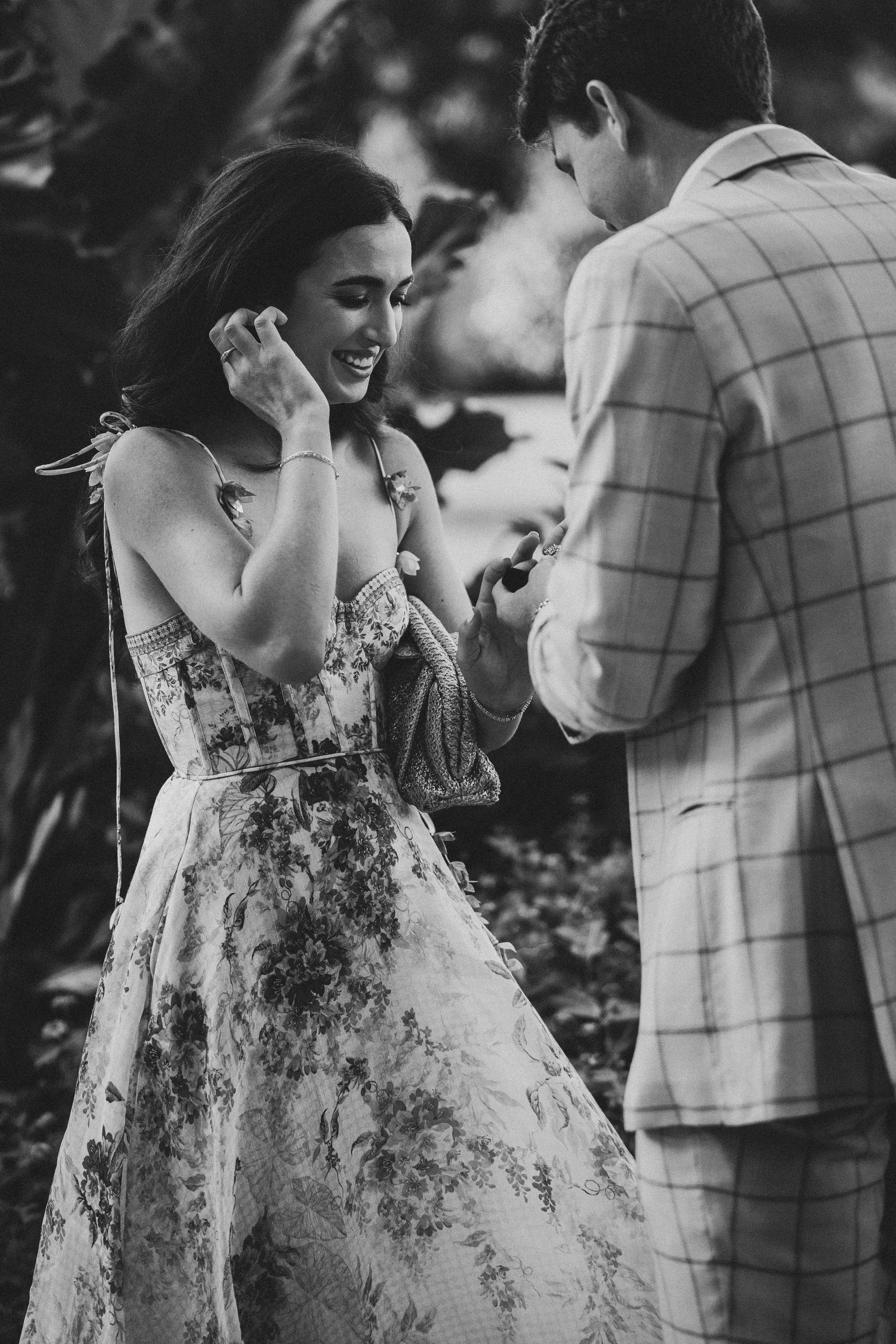 Candid black and white shots capture tender moments between a couple in a garden setting.