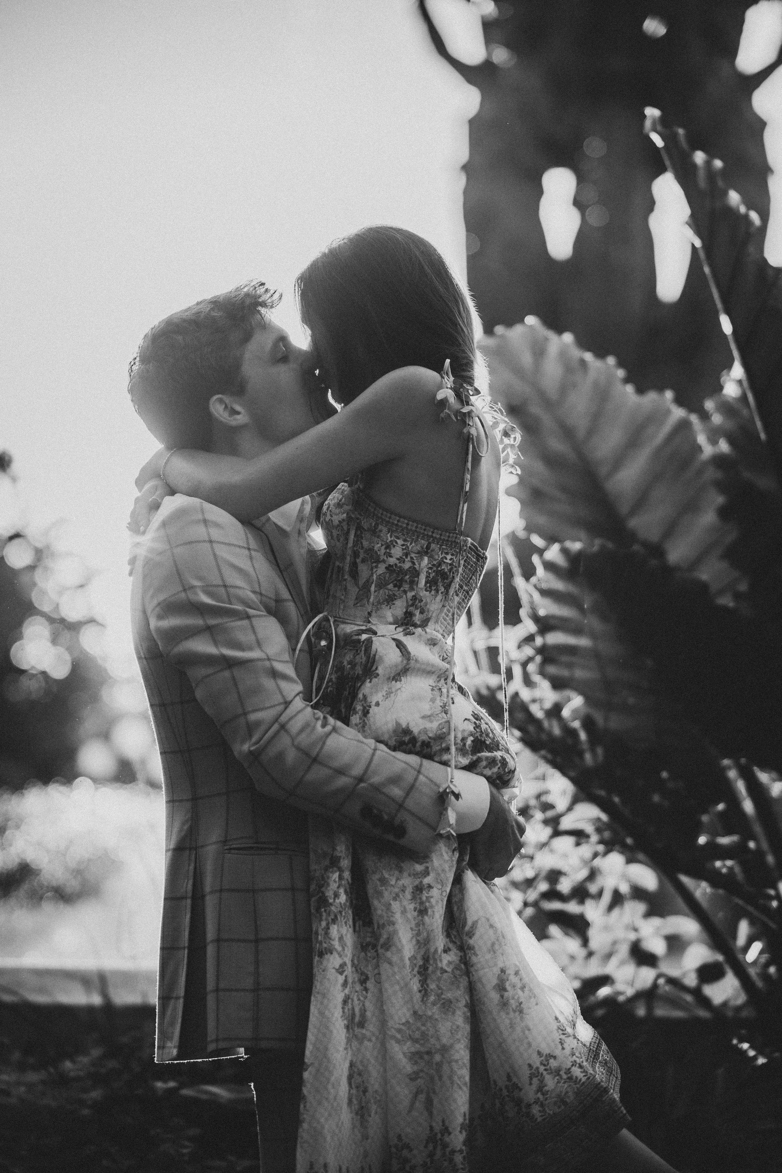 A romantic black and white photo sequence shows a couple embracing and dancing together in soft natural lighting.