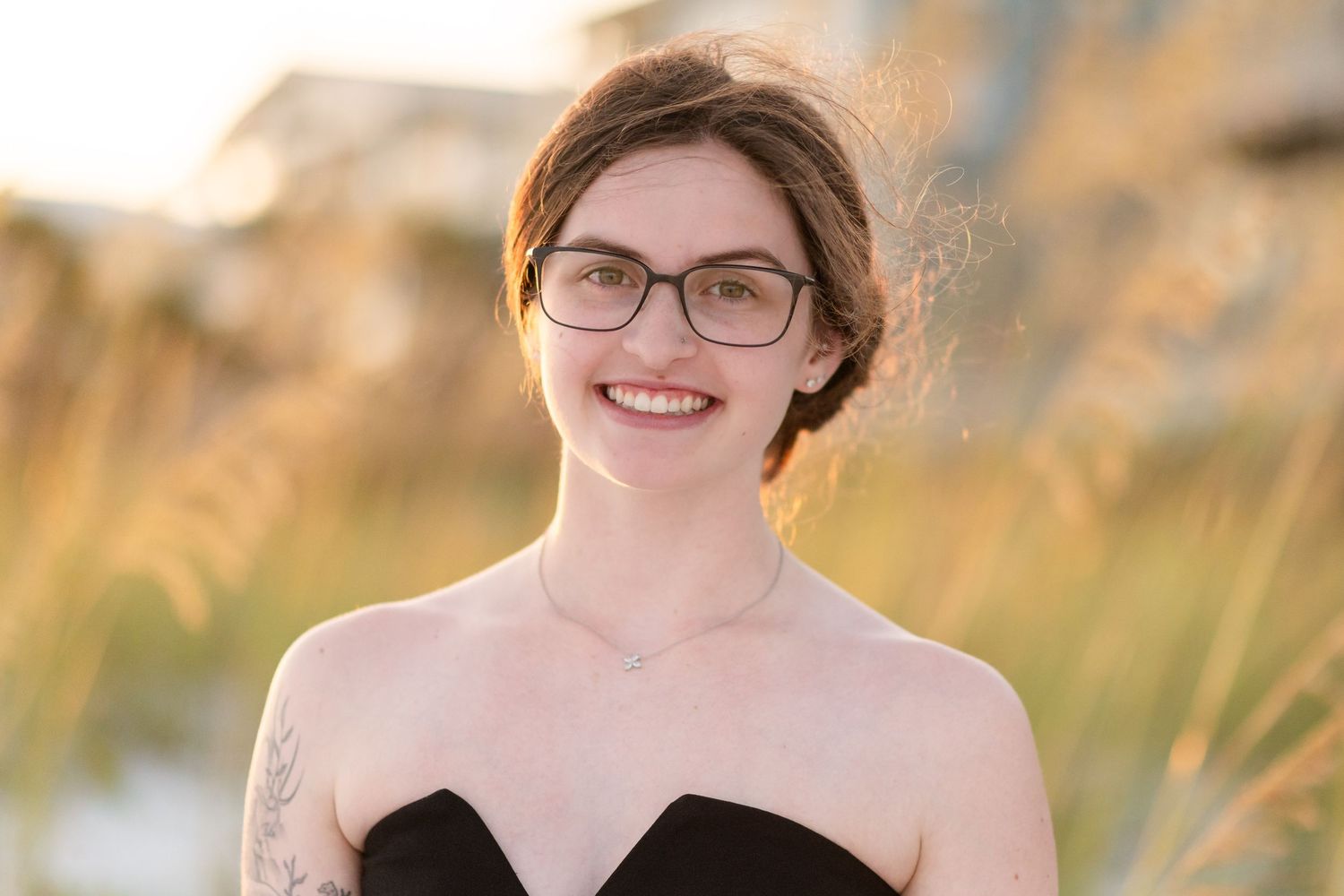 A series of four similar portraits showing someone with glasses and short hair smiling outdoors in golden sunlight.