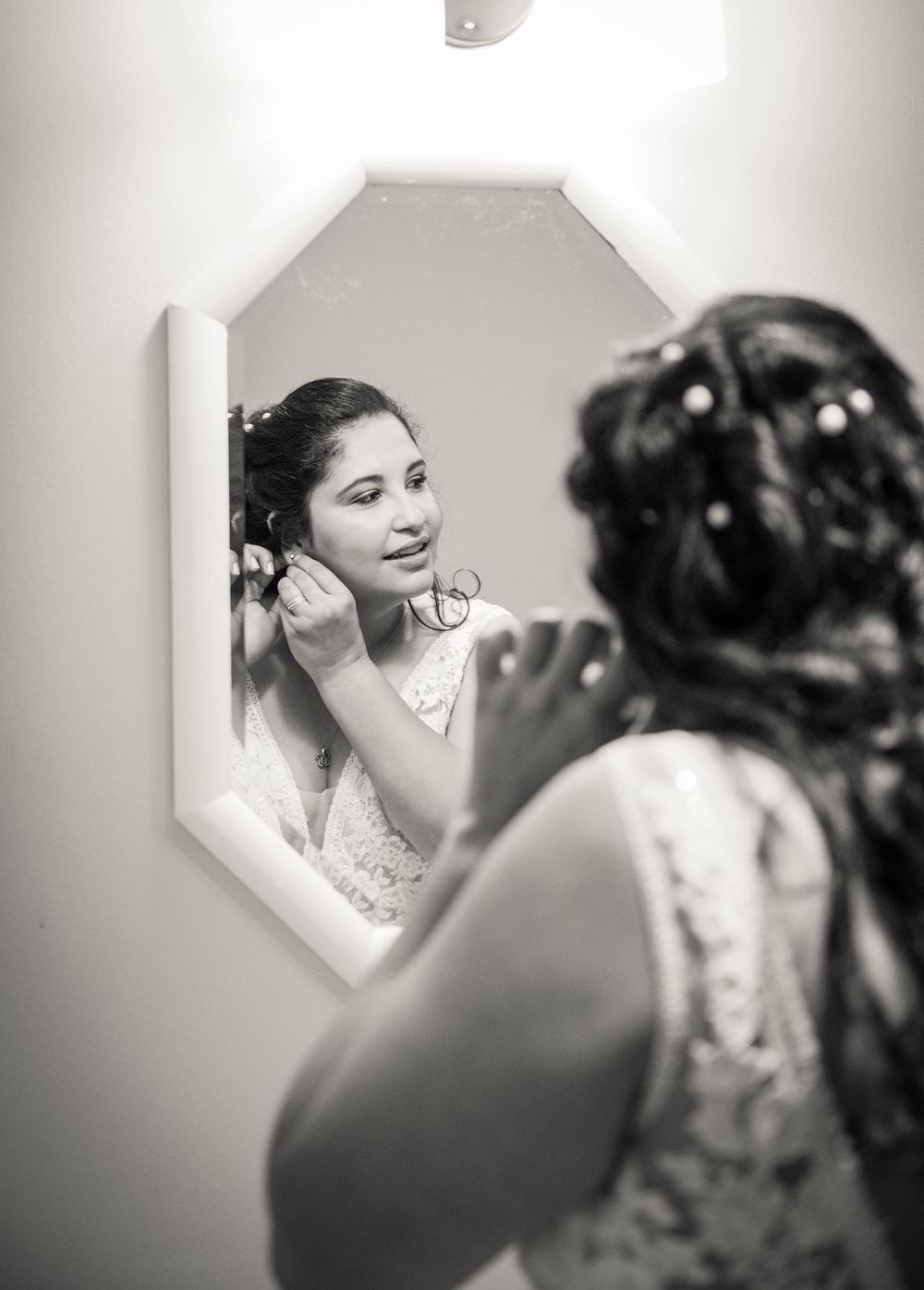 Black and white reflection of wedding preparations in an octagonal mirror.