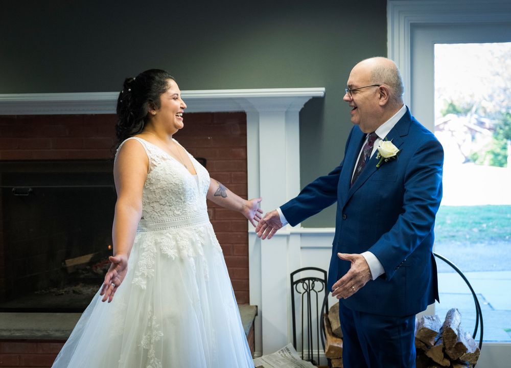 A couple shares a romantic dance together during their wedding reception in a sunlit venue.