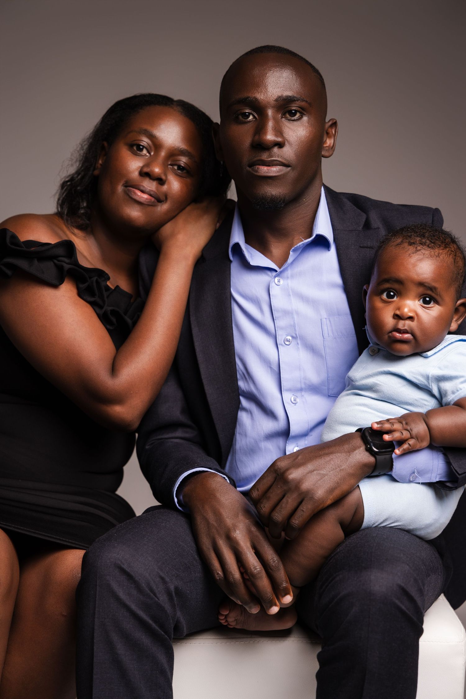 A family portrait in studio lighting with dramatic shadows.