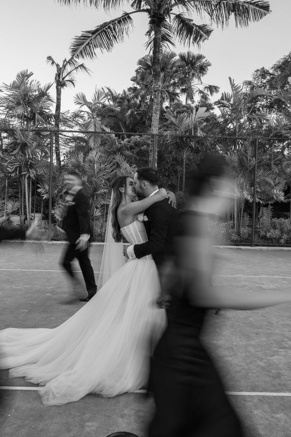 A sequence of black and white photos showing a couple dancing together outdoors among palm trees.