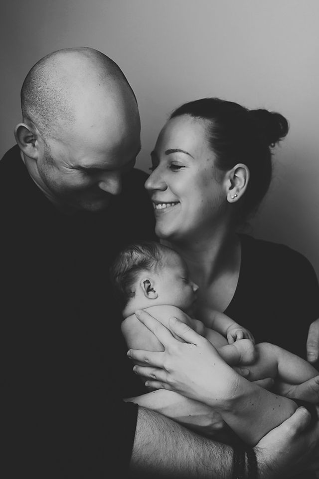 A collection of black and white photographs capturing loving family moments between parents and their infant.