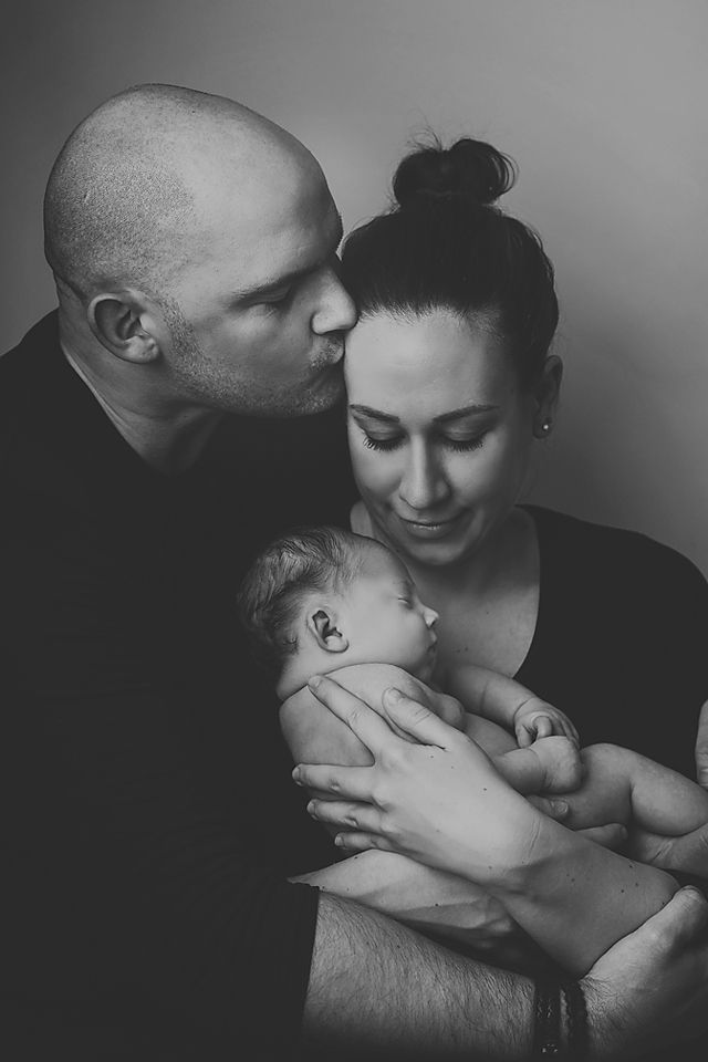 A series of intimate black and white photographs showing tender moments between a couple and their baby.